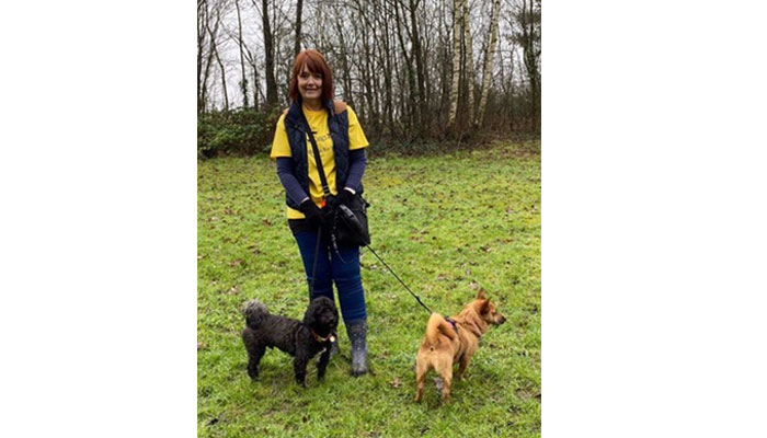 dog walker and pet sitter holding black spaniel 